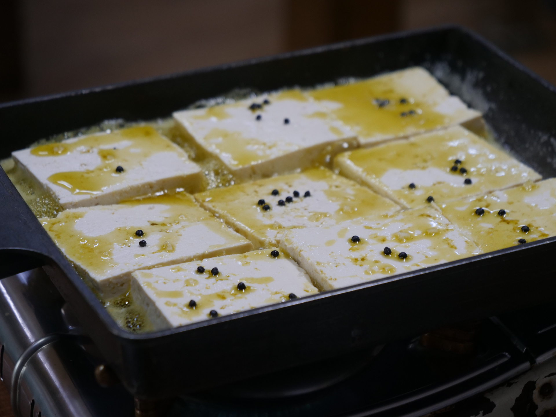 Traditional Korean tofu dish with black beans and herbs served on decorative ceramic plate